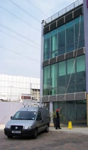 Commercial window cleaner working with water fed pole Image thanks to TMS Specialist Cleaning